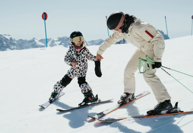Happy mother and daughter skiing on a sunny day