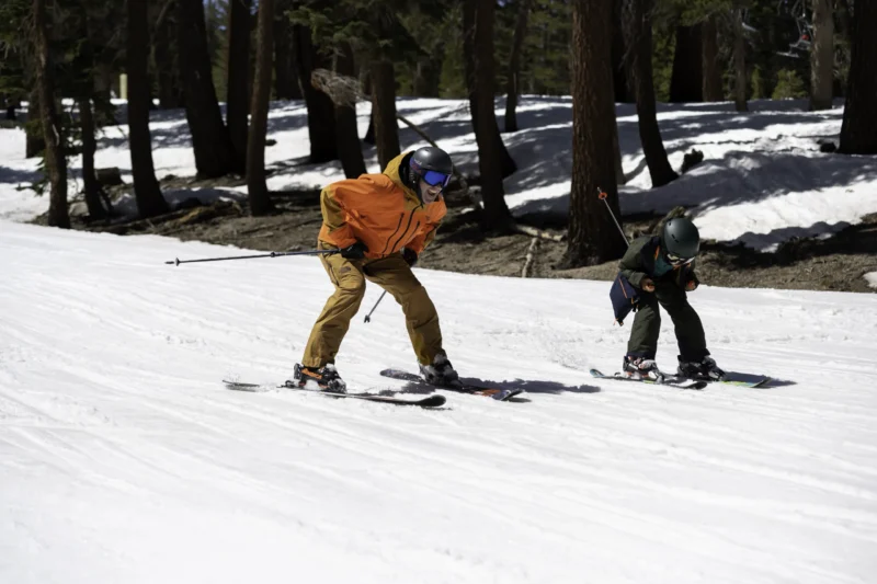 Man and child skiing downhill